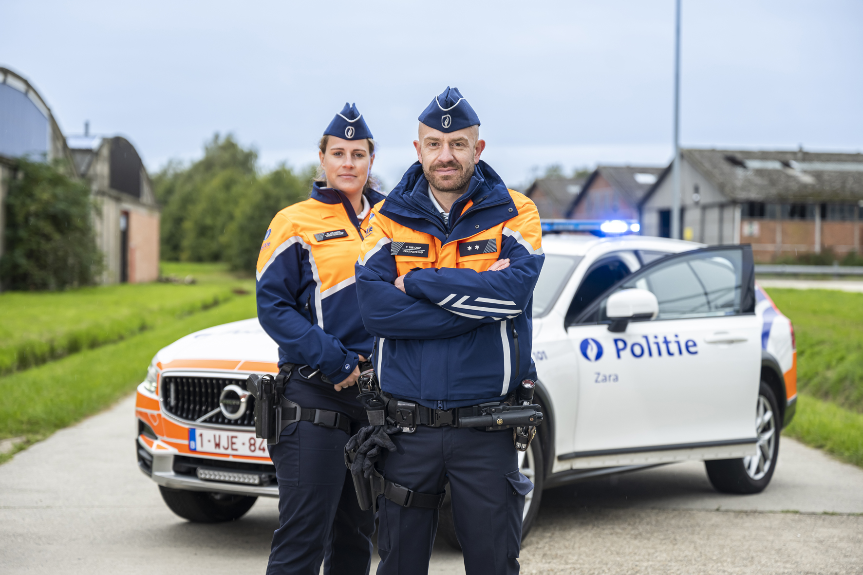 Twee politieinspecteurs kijken in de lens voor het interventievoertuig