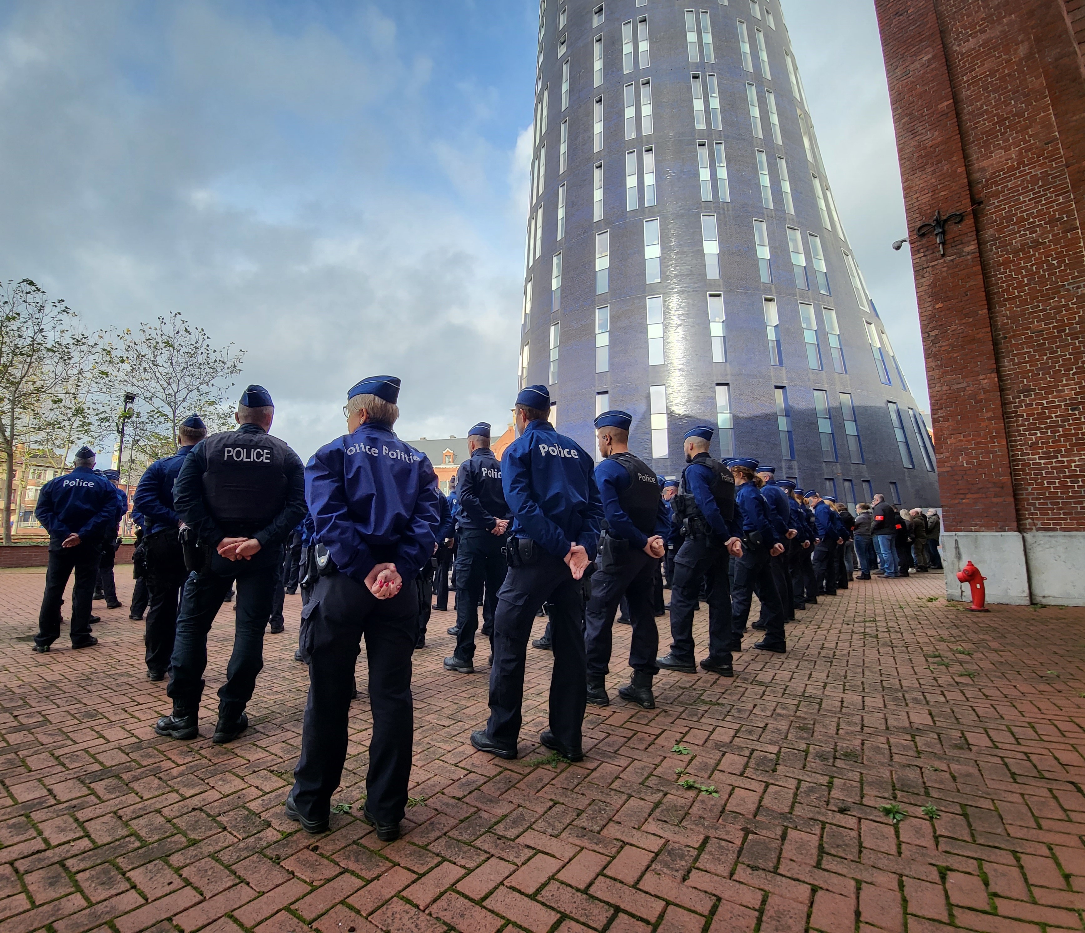 peloton en tenue au pied de la tour bleue de police de Charleroi