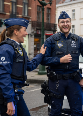 vrouwelijke en mannelijke politie inspecteur buiten al lachend