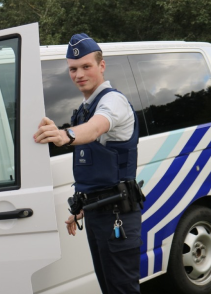 Politieman opent de deur van het dienstvoertuig