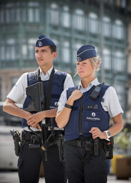 Männlicher Inspektor mit Waffe in der Hand und weiblicher Inspektor mit Funkgerät in der Hand