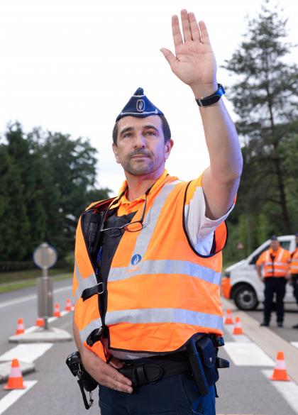 Mannelijke inspecteur van verkeer doet het verkeer stoppen