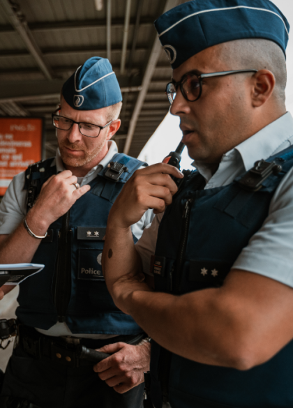 twee politie inspecteurs in uniform op perron