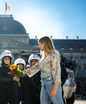 Een burger overhandigt een boeket bloemen aan personeelsleden.